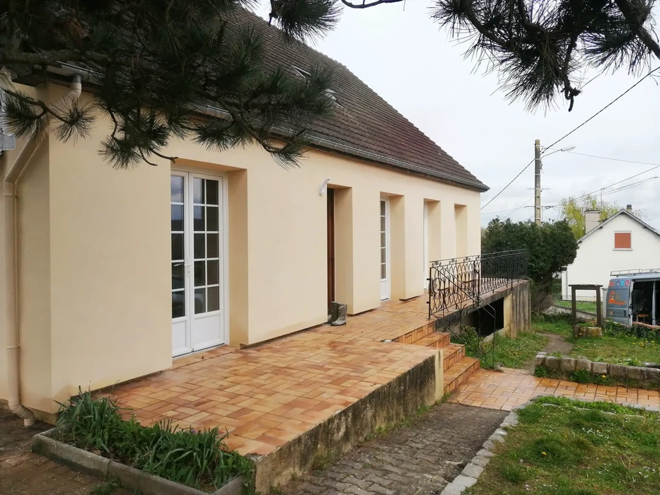 Terrasse extérieure rénovée d'une maison individuelle avec carrelage terre cuite, garde-corps métallique noir forgé