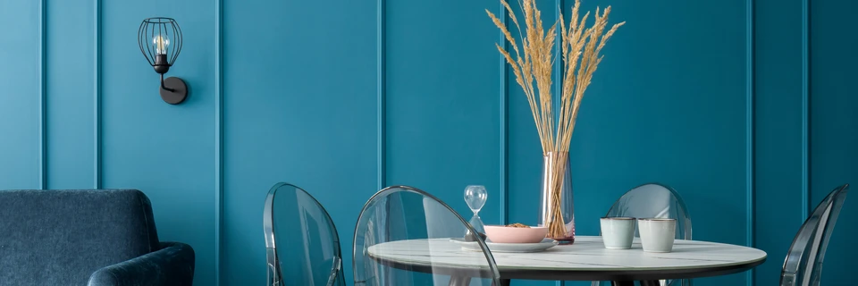 Salon moderne minimaliste avec canapé bleu ciel, fauteuil assorti et table basse ronde en bois clair