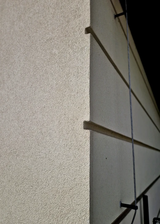 Surface en béton brut gris clair présentant une texture naturelle avec imperfections et marques de coulage