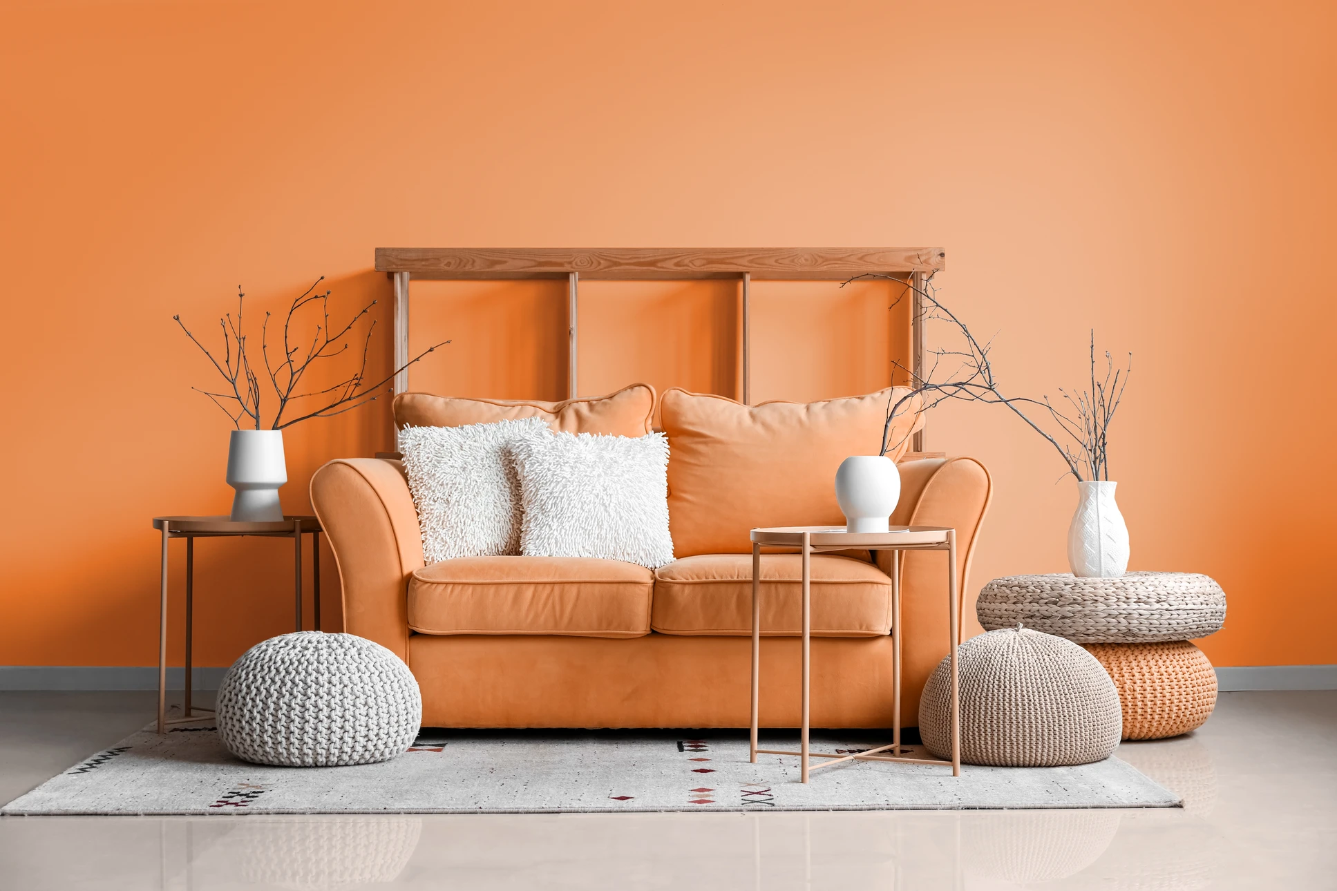 Artisan peintre souriant dans atelier blanc tenant échantillons couleurs et rouleau peinture, près échelle bois