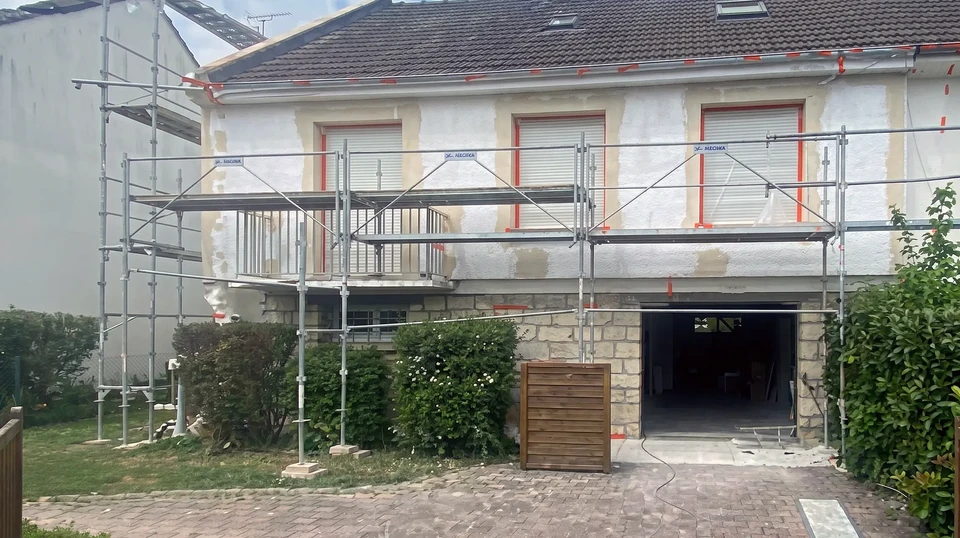 Chantier de construction résidentielle en cours, murs extérieurs avec ossature bois apparente et isolation thermique en laine de verre entre montants
